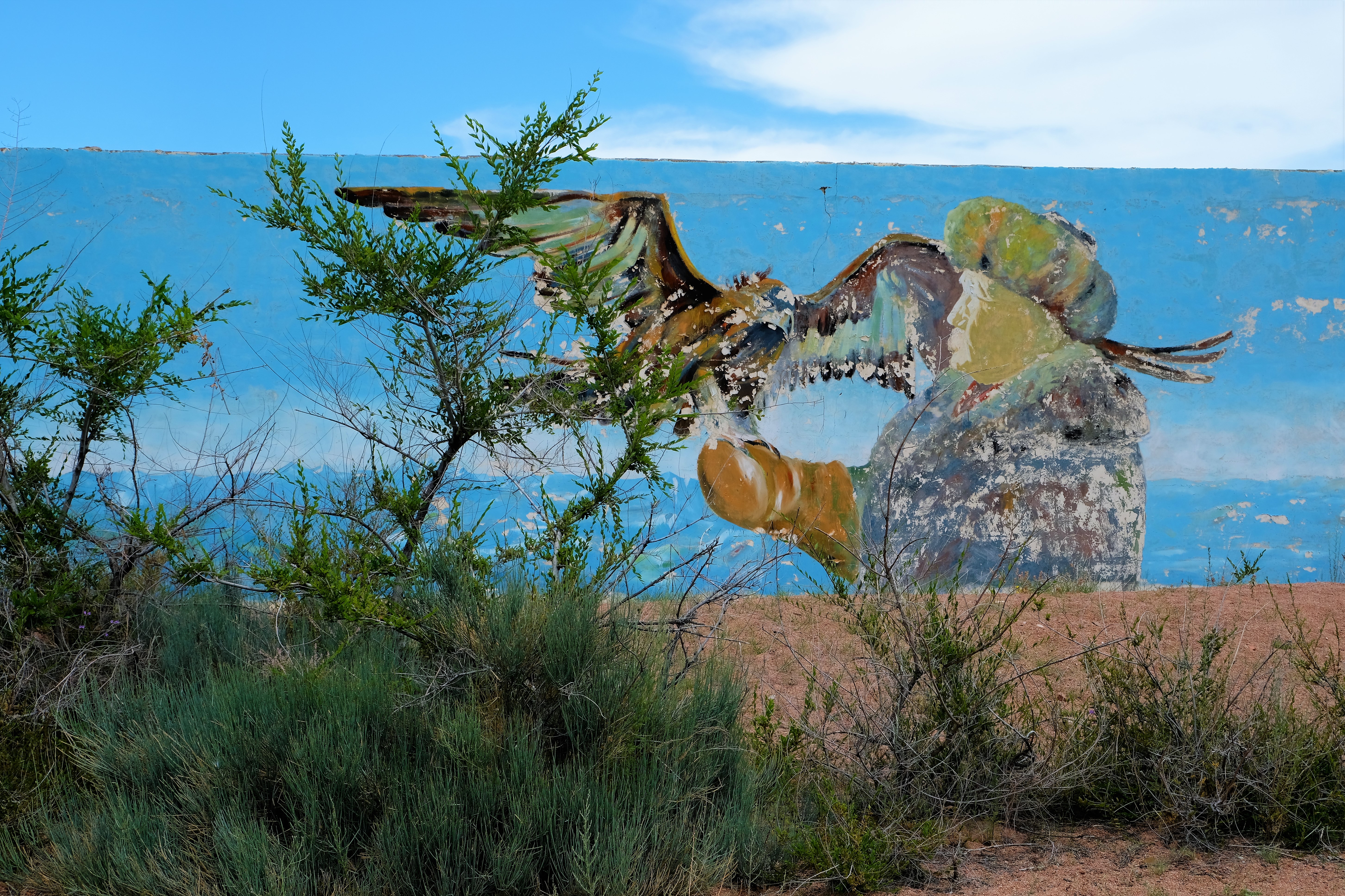 Fading mural of an old man with his falcon who sits on his arm