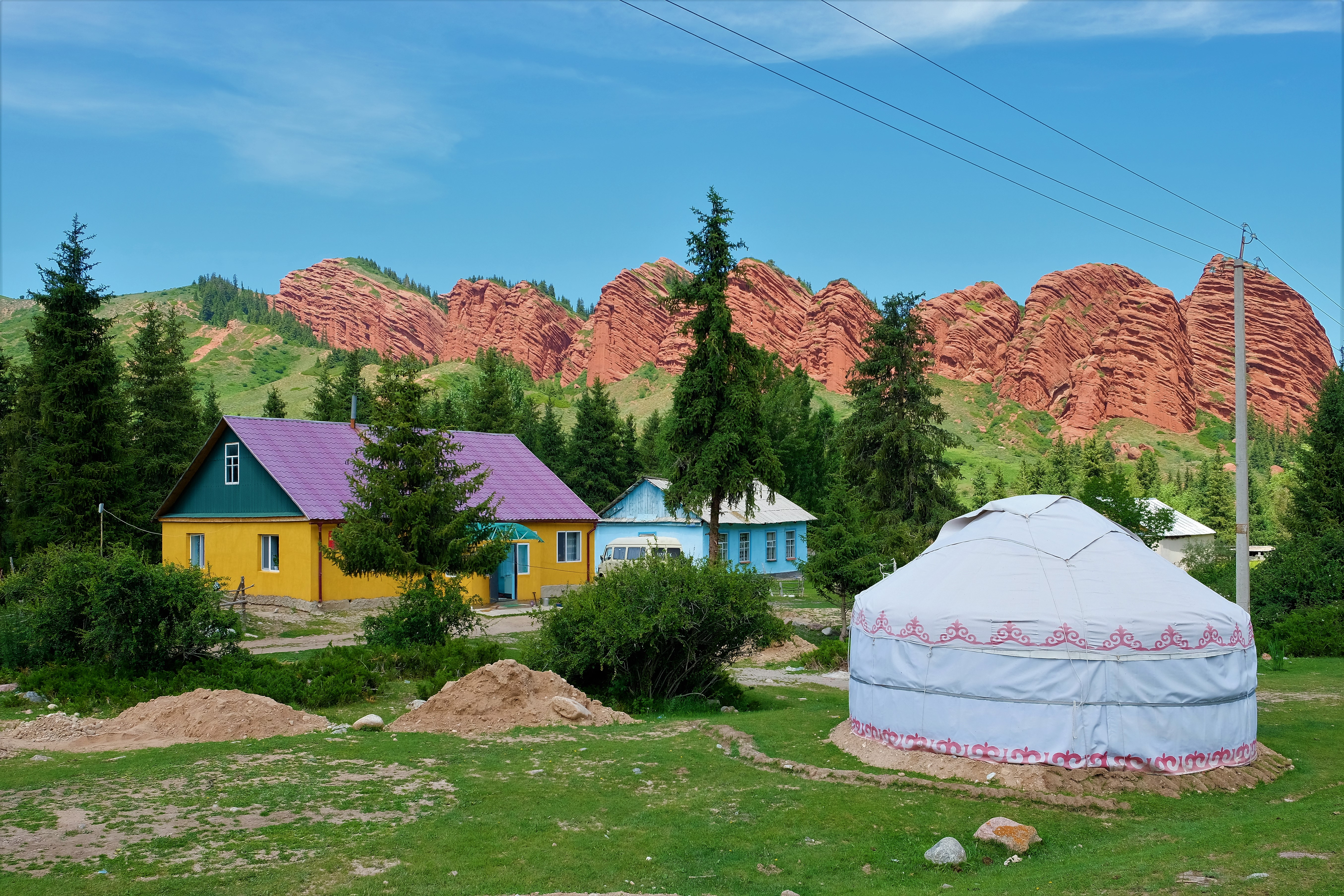 A yurt and cloorful houses of hte village at the foot of the Seven Bulls